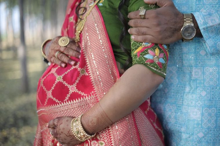 Expectant mother in a traditional saree holding her belly