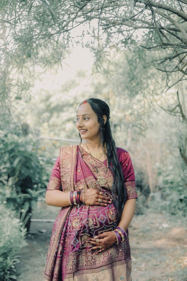 Smiling expectant mother in a traditional saree
